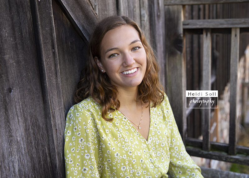 cute and relaxed senior picture outside a barn in St Paul MN 