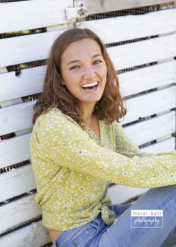 fresh and natural expression of a high school senior girl laughing during her outdoor photo session